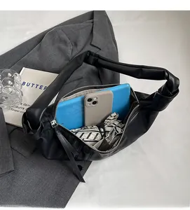 Detail view of the spacious interior of this black PU leather bag holding a tablet and phone