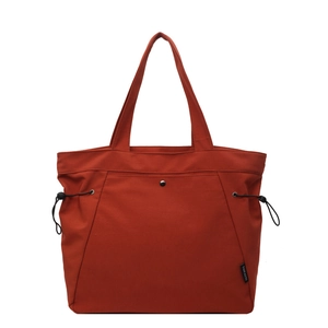 Minimalist brick red canvas tote bag with metal snap pocket and side drawstrings