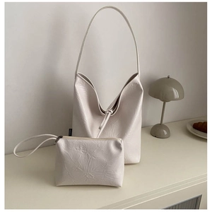 Minimalist beige PU leather tote bag set with matching pouch on a stylish desk