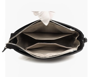 Detailed interior view of leather handbag showing gray lining and multiple pockets