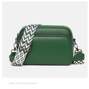Detail of dark green lychee grain leather bag with decorative geometric woven strap
