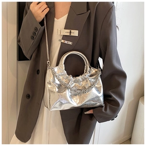 Detail of silver metallic pleated handbag with circular handle and fine chain strap