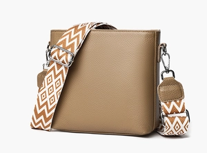 Detail of genuine leather bag with colorful woven wide shoulder strap and silver hardware