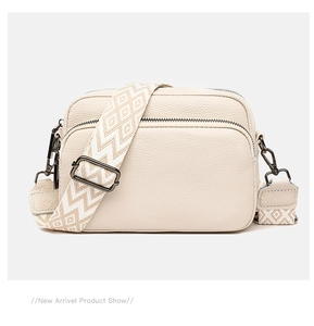 Detail of beige litchi grain leather bag with double zippers and jacquard strap