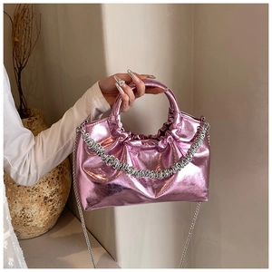 Close-up of metallic pink PU leather handbag with pleated texture and silver chain strap