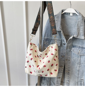 Detailed close-up of corduroy tote with strawberry print and vintage jacquard strap