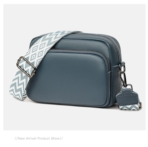 Close-up of dark blue lychee grain leather camera bag featuring dual-zipper compartments