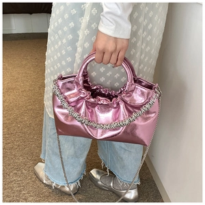 Detail view of pink metallic cloud bag with silver chain strap and top handle