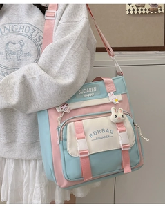 Detail of multi-color nylon crossbody bag featuring cute rabbit charms and logo