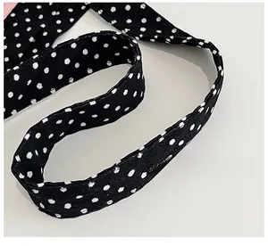 Detailed view of the soft woven strap on a retro polka dot canvas tote bag