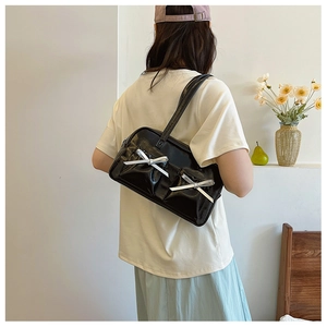 Détail d'un sac à bandoulière noir en cuir PU avec des nœuds argentés décoratifs