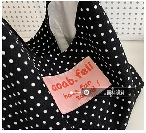 Detailed macro shot of vintage polka dot canvas fabric with pink logo patch and text