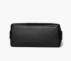 Detailed close-up showing the pebbled leather texture and stitching on the black handbag