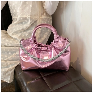 Detail of pink metallic handbag featuring ruched design and stylish silver chain strap