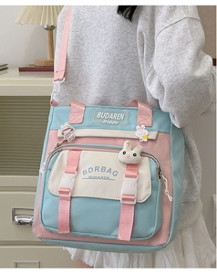Close-up of nylon tote bag with cute plush rabbit charm and colorful cartoon badges