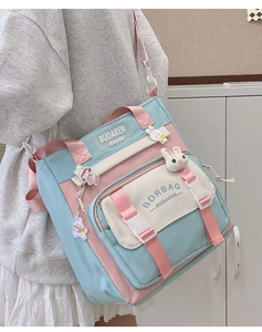 Detail showing the pastel pink and blue nylon crossbody bag with cute bunny charms
