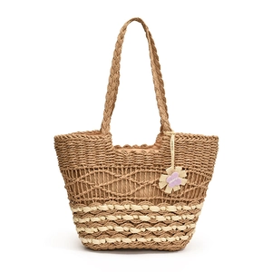Straw woven tote bag in brown and white with decorative flower pendant for spring fashion