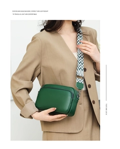 Detail of dark green lychee pattern leather crossbody bag with geometric woven strap