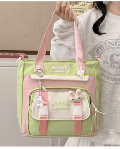 Close-up of pastel nylon tote bag showing plush bunny charm and detailed pockets