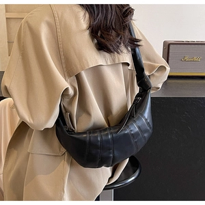 Detail of black PU leather croissant bag with quilted pleats and soft texture for women