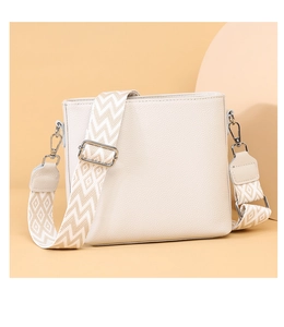 Detail of white litchi grain leather bag with patterned wide fabric shoulder strap