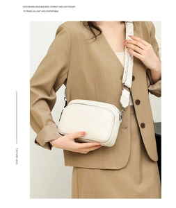 White lychee leather shoulder bag with geometric jacquard strap worn over a blazer