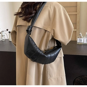 Minimalist black PU leather croissant bag with pleated design worn by model