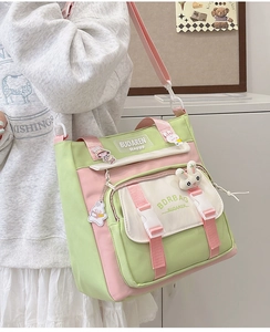 Detail of multi-compartment nylon crossbody bag with cute bunny pendant and pastel panels
