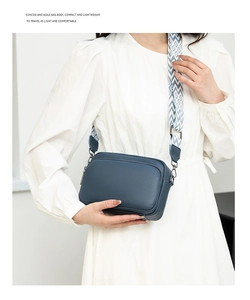 Detail of blue lychee grain leather bag featuring a patterned wide fabric strap