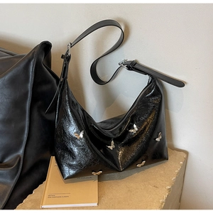 Chic black crescent PU shoulder bag with silver butterfly charms and adjustable strap