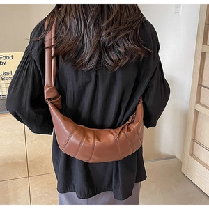Detailed view of the brown PU leather croissant bag worn as a stylish crossbody bag