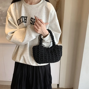 Borsa a secchiello minimalista nera tessuta a mano con texture a maglia e doppi manici