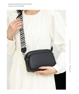 Detailed macro view of black lychee leather bag texture with stylish geometric woven strap