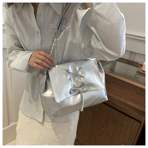 Detail of silver metallic tote bag with decorative drawstrings and bow accents