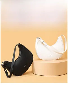 Detail of minimalist half-moon shoulder bags in black and white with STLY logo and silver hardware