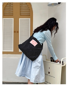 Detail of large canvas tote bag with retro white polka dots and pink logo patch