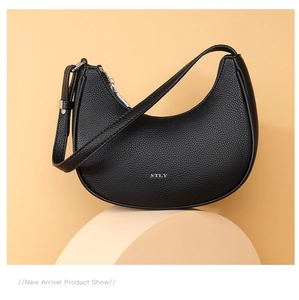 Detail shot of black crescent shoulder bag featuring pebbled leather and silver metal zipper