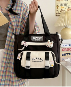 Detail of nylon crossbody bag with cute charms and brand logo in a cozy indoor setting