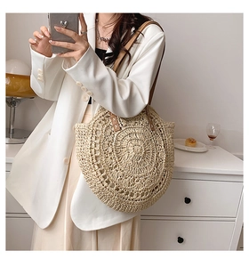 Detailed macro view of the handcrafted straw texture and semi-circular weave on the tote bag