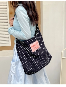 Detail of large canvas tote bag with retro polka dots and pink logo patch decoration