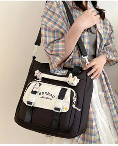 Detail of nylon crossbody bag featuring cute cartoon patches and BDRBAG logo
