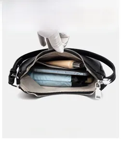 Internal view of the black pebbled leather bag showing spacious compartments and storage