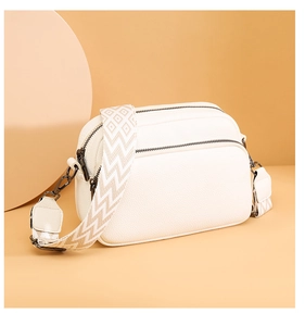 Détails du sac bandoulière en cuir grainé blanc avec plusieurs zips et large sangle tissée