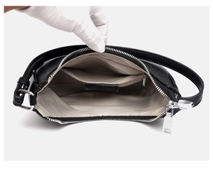 Detail view of black pebble leather handbag with gray herringbone lining and inner pockets