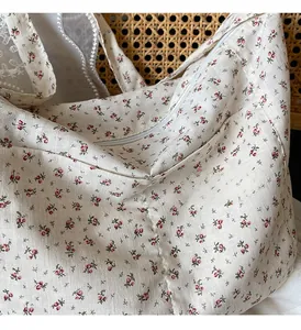 Close-up of floral print fabric tote bag with zipper closure and natural linen texture