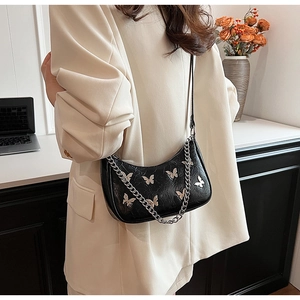 Détail du sac demi-lune en PU noir avec papillons argentés et bandoulière en chaîne
