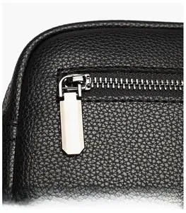 Détail de cuir noir à texture litchi avec zips argentés polis et tirettes allongées