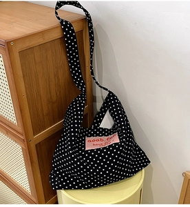 Detailed macro shot of vintage polka dot canvas tote with pink aoab.fell label