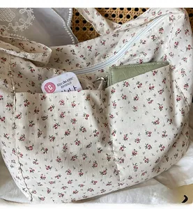 Detail of floral canvas tote bag with functional outer pockets and zipper closure