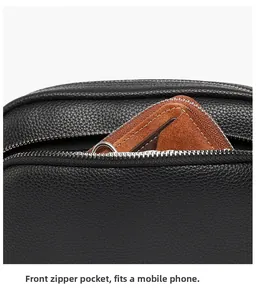 Vue macro de la poche avant zippée d'un sac à bandoulière en cuir noir texturé